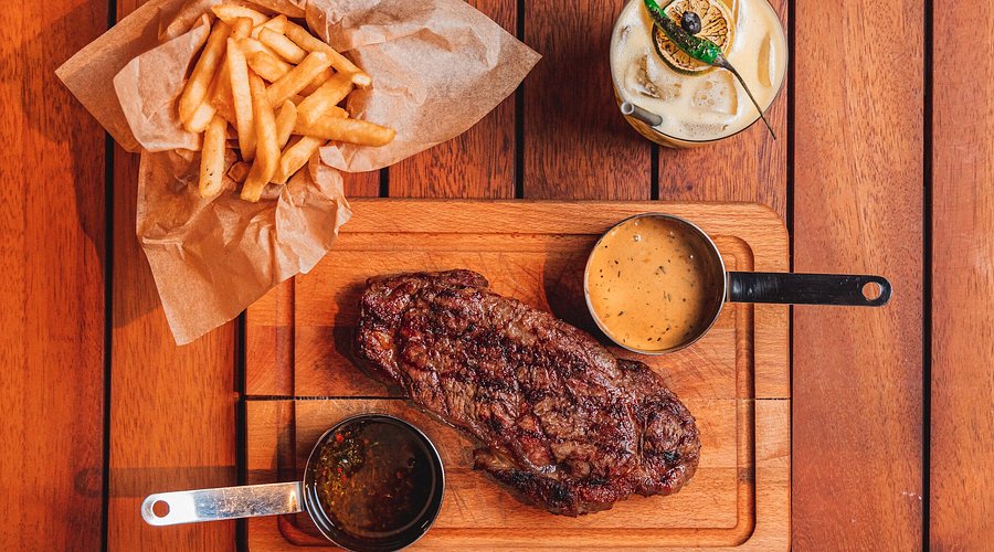 Azar Open Fire Cuisine steak board with fries and cocktail