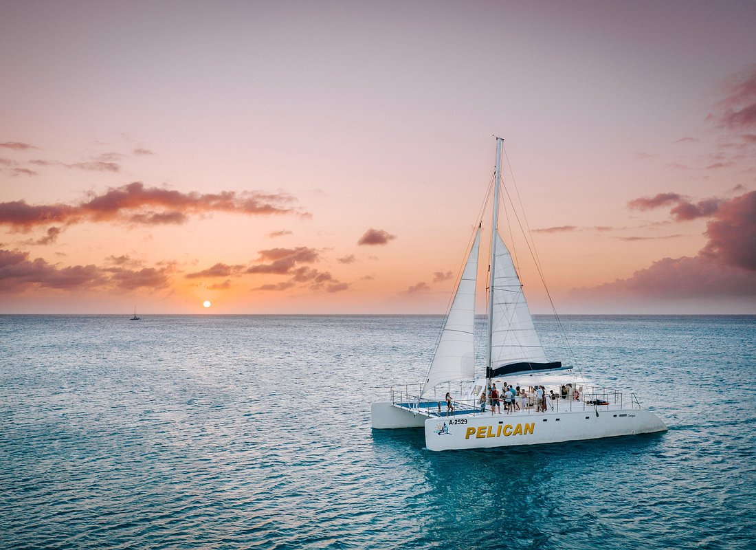 Pelican catamaran sailing into an Aruba sunset